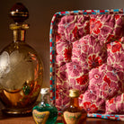 Close-up of Poppy Magnolia Vanity Bag showing quilted pink and red floral fabric with checkered trim detail