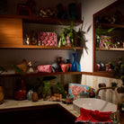 Poppy Magnolia Vanity Bag styled on shelves and bathroom counter in a richly decorated boho interior
