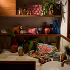Poppy Magnolia Vanity Bag displayed on wooden shelves and tiled counter in a styled bathroom setting