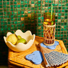 Azure blue marbled resin coasters styled on a bamboo table with a drink and citrus fruit bowl
