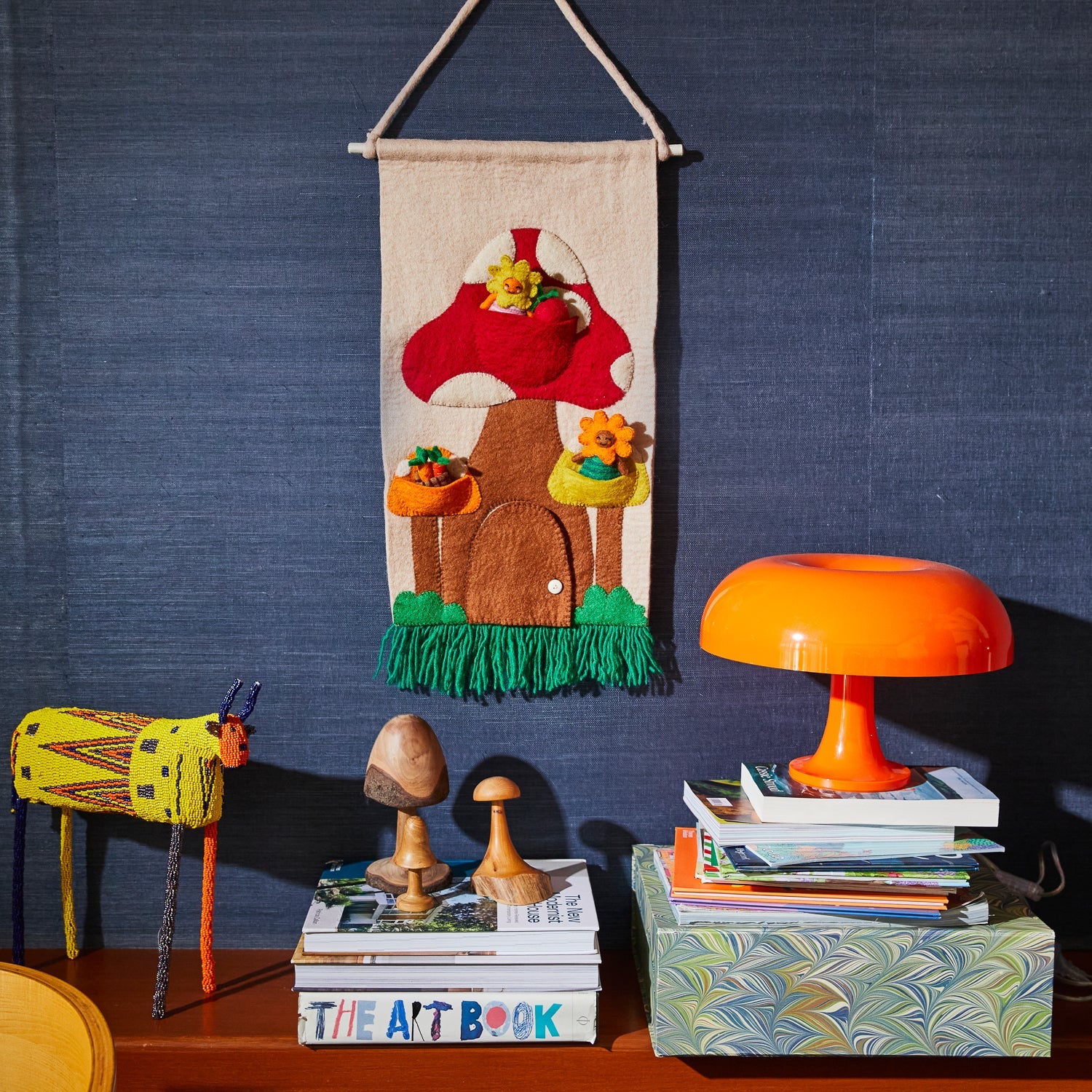 Margette Felt Wall Hanging displayed in children's room with red mushroom design and wood hanging rod