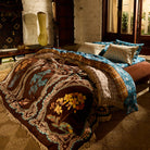 Brown velvet bedcover with botanical medallion print and cream fringe draped across a styled bed in a warm boho bedroom