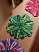 Colorful floral-patterned bath mats by Bonnie and Neil on a tiled floor