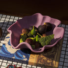 Stacked collection of bowls with orchid at bottom and cream yellow lime green bowls nested above