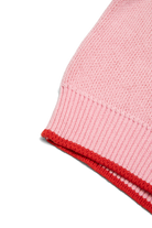 Detail shot of pink knit sweater sleeve hem showing red contrast ribbed cuff trim