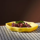 Aspen Gold Nicole Serving Dish filled with red grapes on a mosaic tile surface, warm studio lighting
