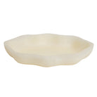 Nicole Serving Dish in Pearl — shallow organic-shaped dish with undulating rim and smooth creamy finish, side view