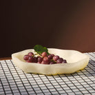 Pearl Nicole Serving Dish holding a bunch of red grapes, placed on a mosaic tile surface with dark background