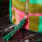 Macro view of gold zipper pull and braided rope cord detail on Nicolette Terry Pouch in Juniper pattern