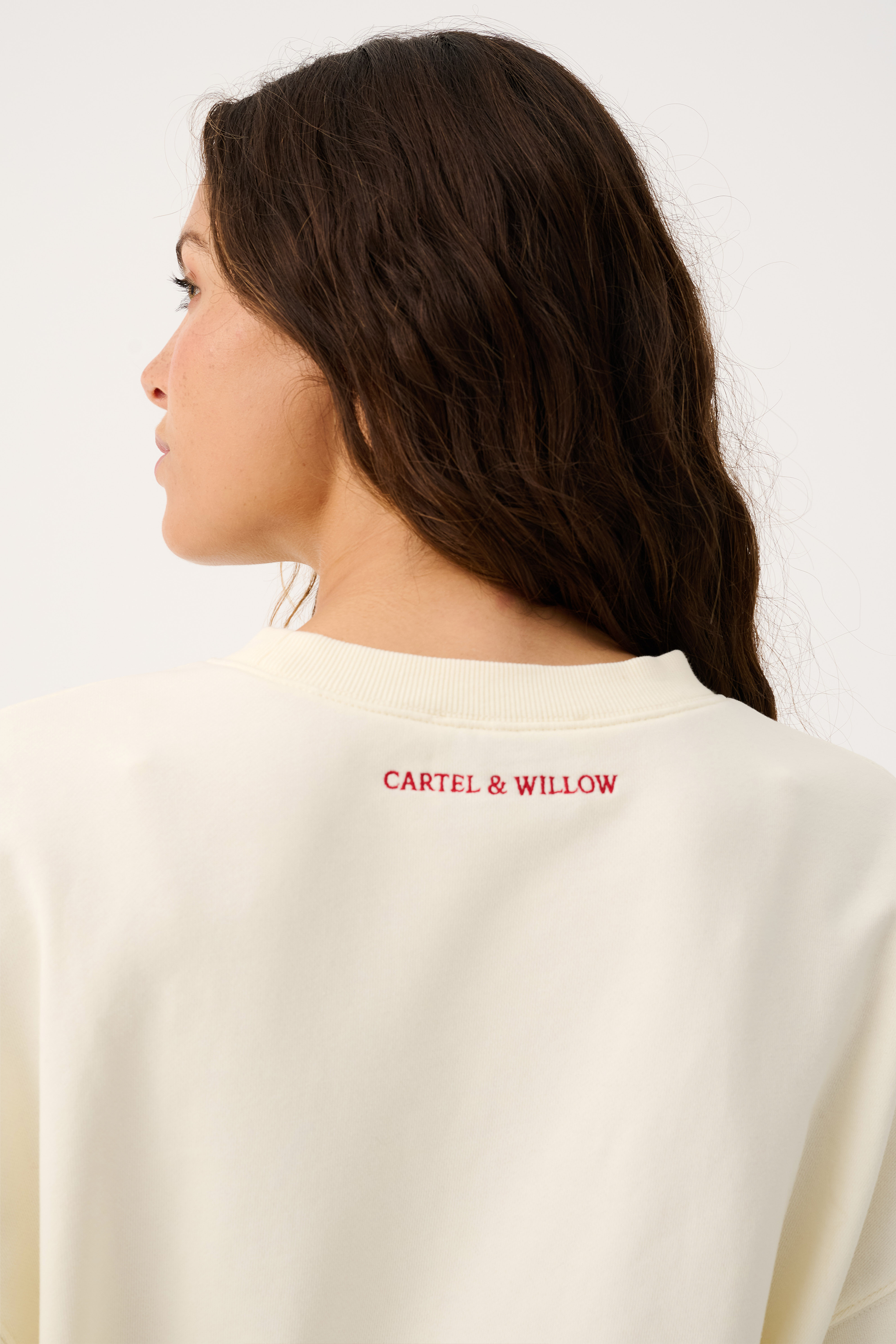 Close-up back detail of Nina Sweater showing red Cartel & Willow logo print on cream fabric