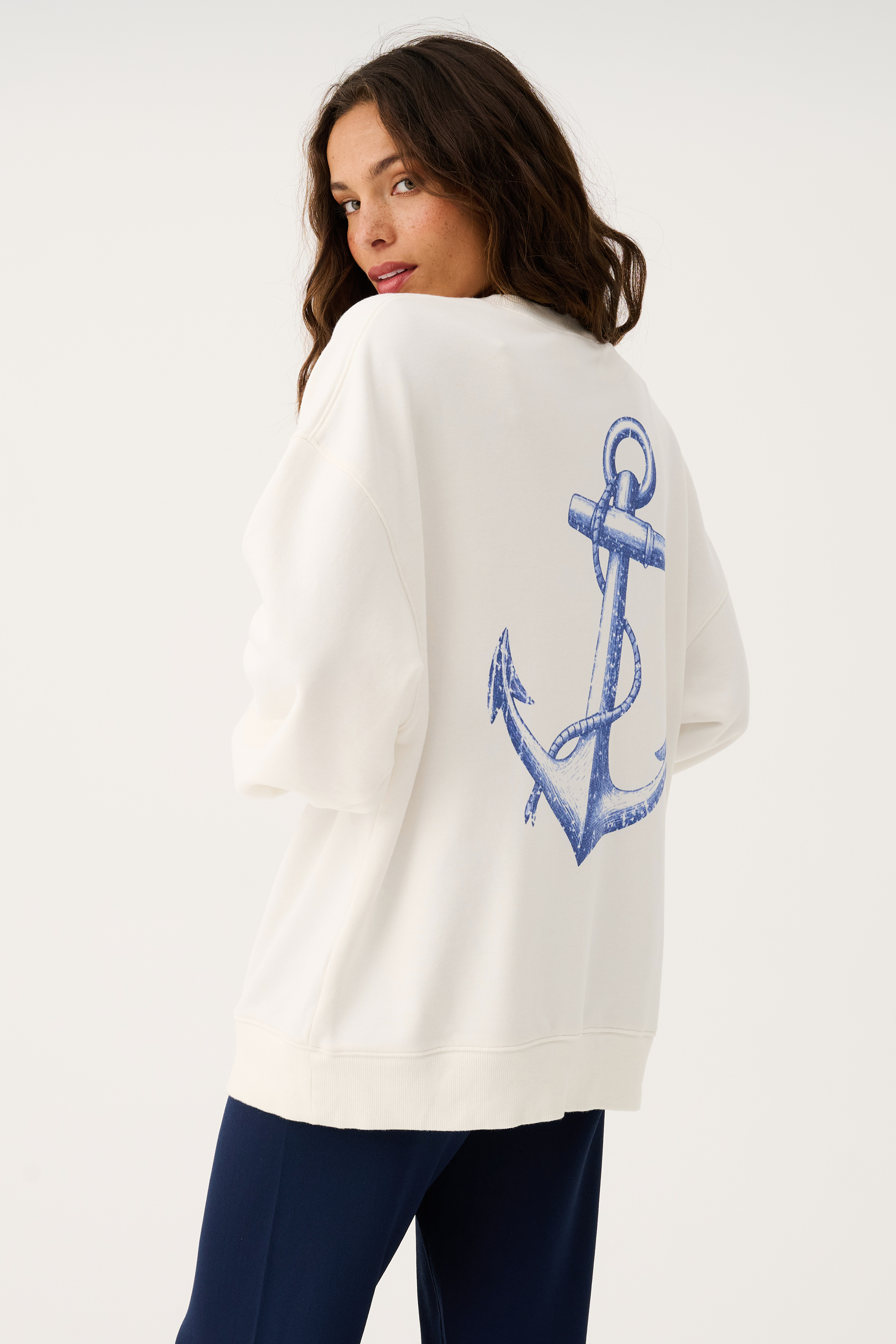 Side angle of Nina Sweater showing blue anchor design on back hem
