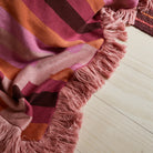 Pink, red and orange knitted blanket for draping over the lounge or bed