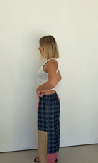 Side profile view showing Olive Checkerboard Pant wide leg silhouette and colorblock construction