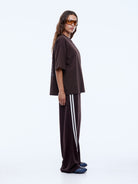 Side profile view of oversized brown Sport Star Tee showing dropped shoulder and loose silhouette