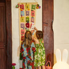 kids putting treats into Palmina Knitted Advent Calendar by Sage & Clare