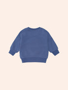 Back view of blue Huxbaby Peekaboo Kel Pocket Sweatshirt showing ribbed cuffs and hemline construction