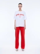 model wearing white tshirts with red writing "Pelly Sport" across the front