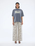 model wearing the grey tshirt with cream logo graphic - Pelly World Tour Tee - Washed Grey by Ena Pelly