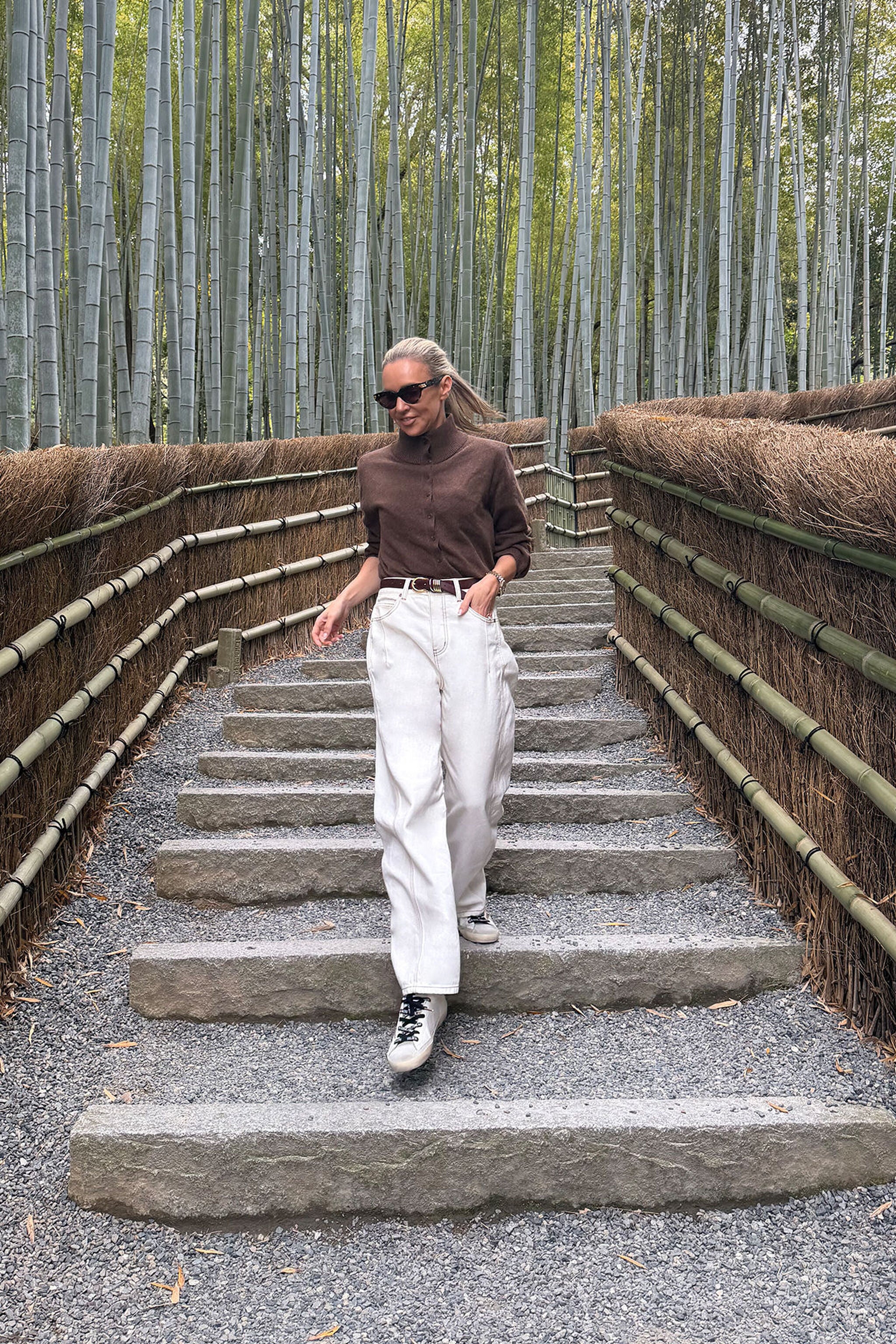 Woman in chocolate marle knit cardigan styled casually walking down bamboo forest pathway