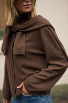 Close-up detail of chocolate marle knit cardigan showing draped collar and button closure construction