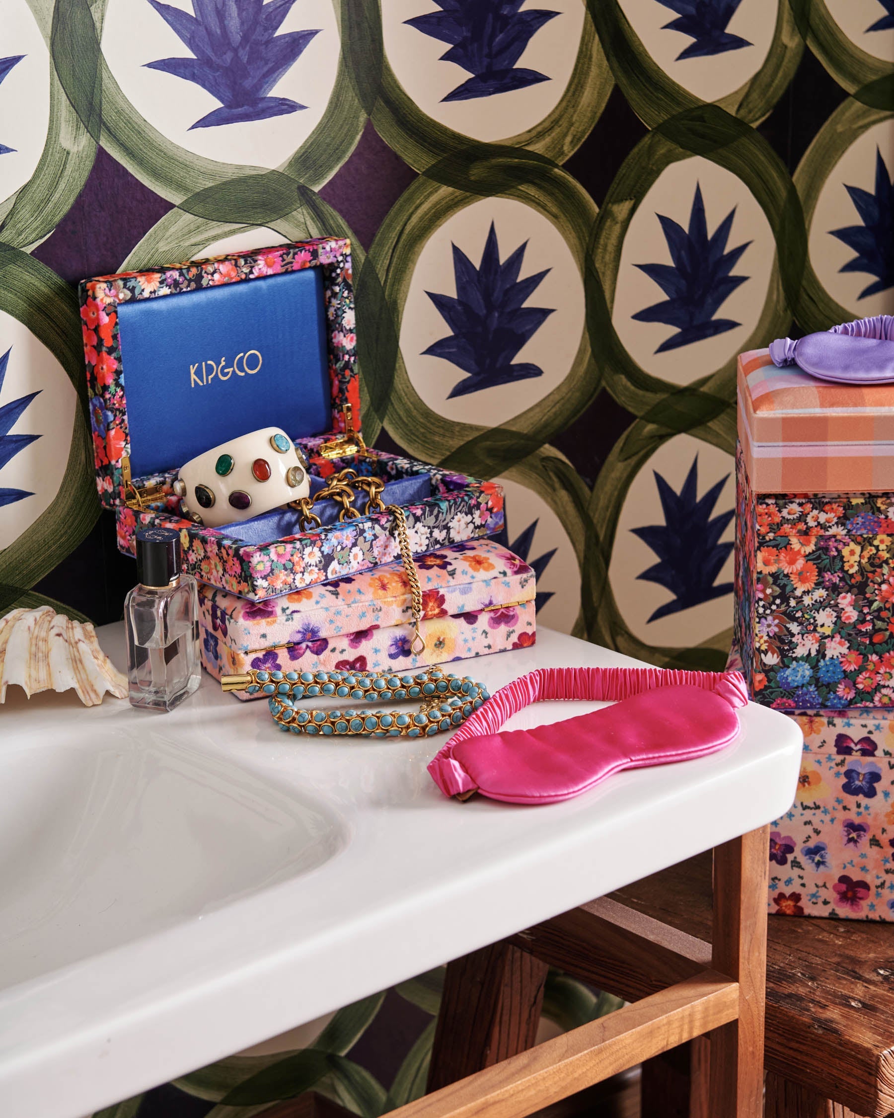 Perfect Pink Silk Eye Mask by Kip & Co styled on white surface with floral jewelry box and accessories