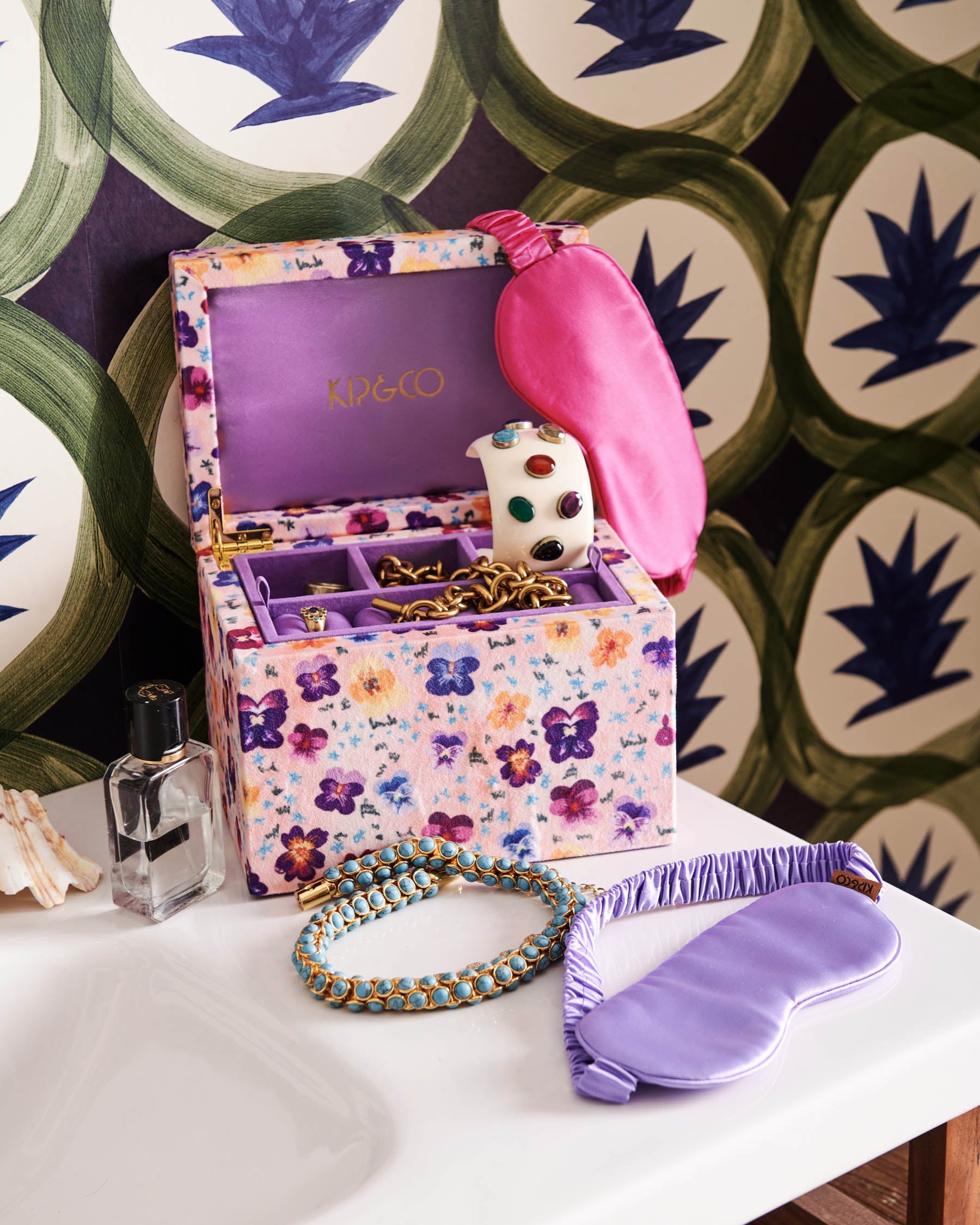 Kip & Co Perfect Pink Silk Eye Mask displayed in open floral jewelry box with purple silk eye mask