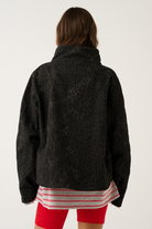 Back view of black washed leopard print oversized jacket showing tonal animal print and high collar