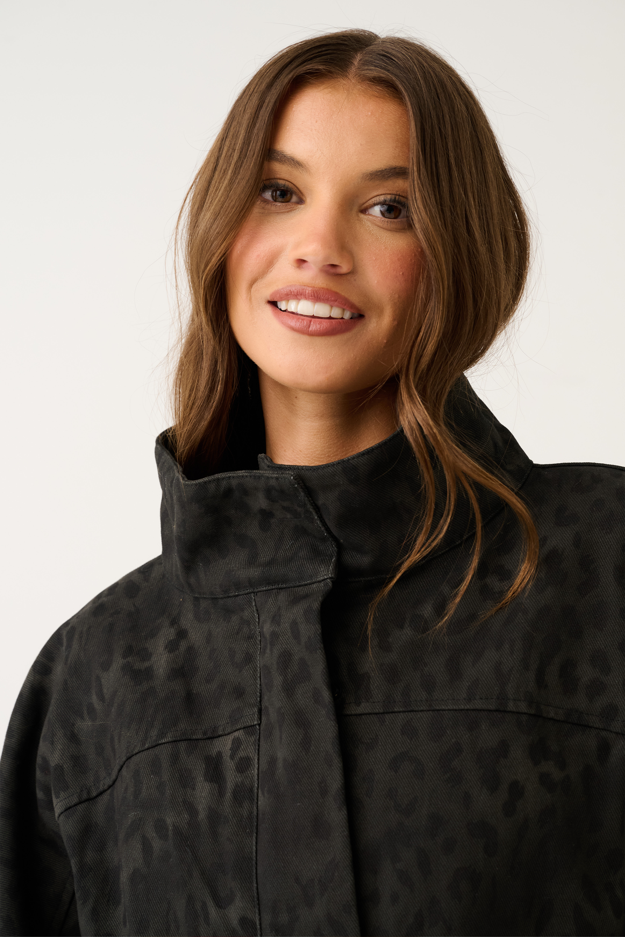 Close-up detail of black washed leopard print jacket collar and tonal animal-print fabric texture