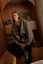 Detail shot of front flap pockets and snap button hardware on Kireina Peyton Bomber jacket