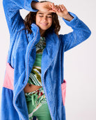 Woman in blue Kip & Co cosy robe with arms raised showing comfortable fit and pink contrast trim