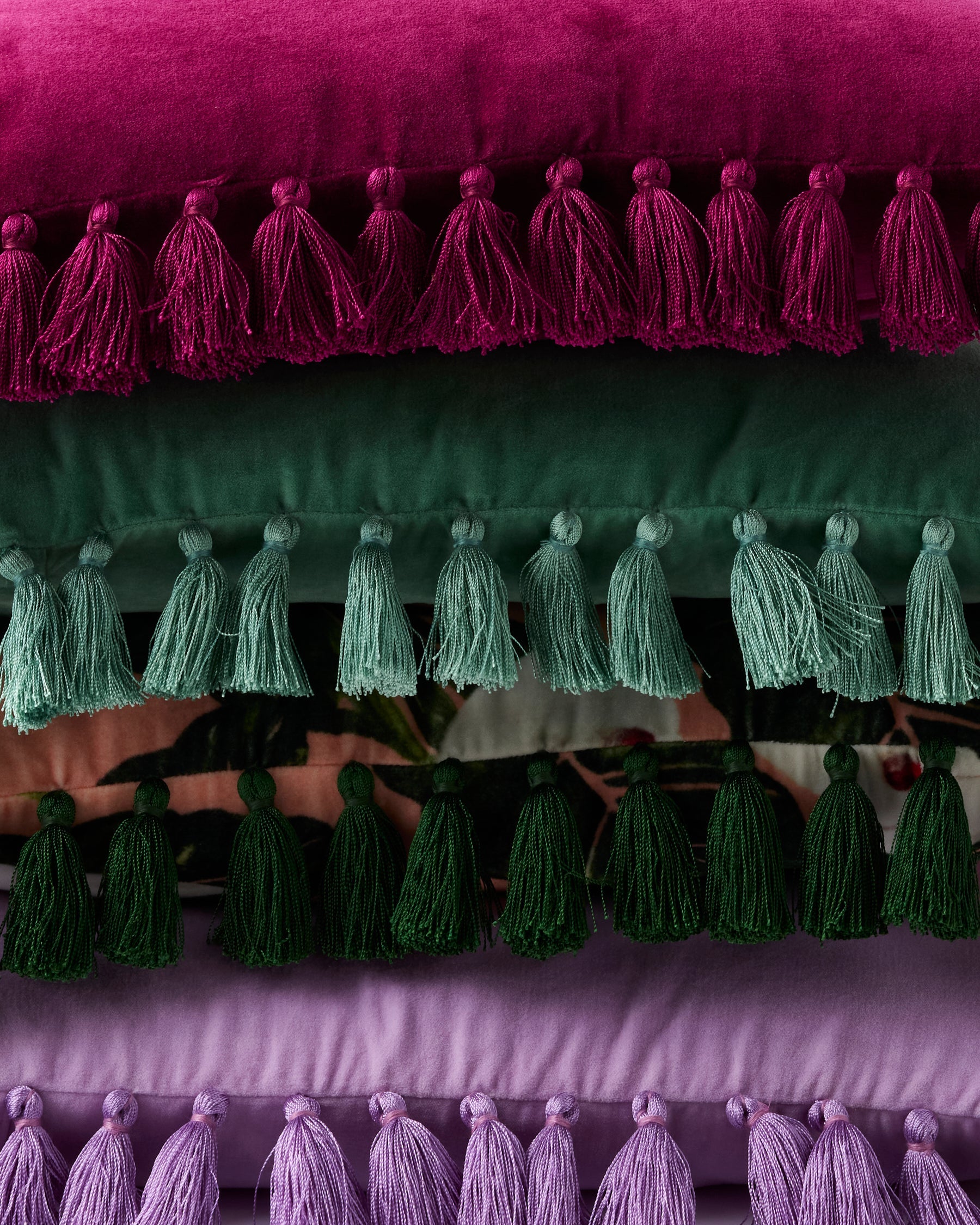 Close-up detail of tassel trim showing purple pink and green velvet cushion edges