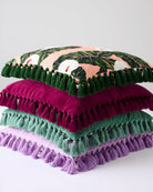Stack of colorful velvet tassel cushions showing pistachio magenta green and lavender options