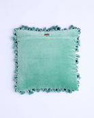 Back view of pistachio velvet tassel cushion showing brand label and tassel trim detail