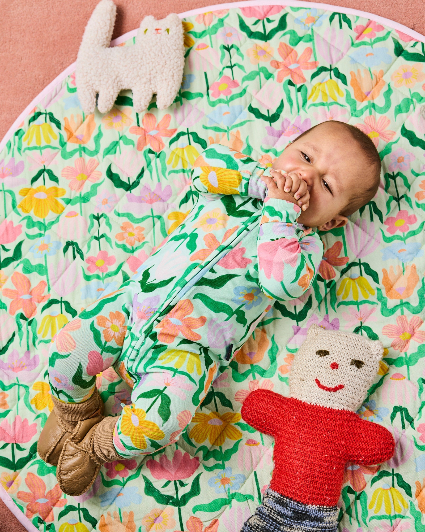 Baby lying on matching Popping Flowers blanket wearing Kip & Co Green Organic Long Sleeve Zip Romper