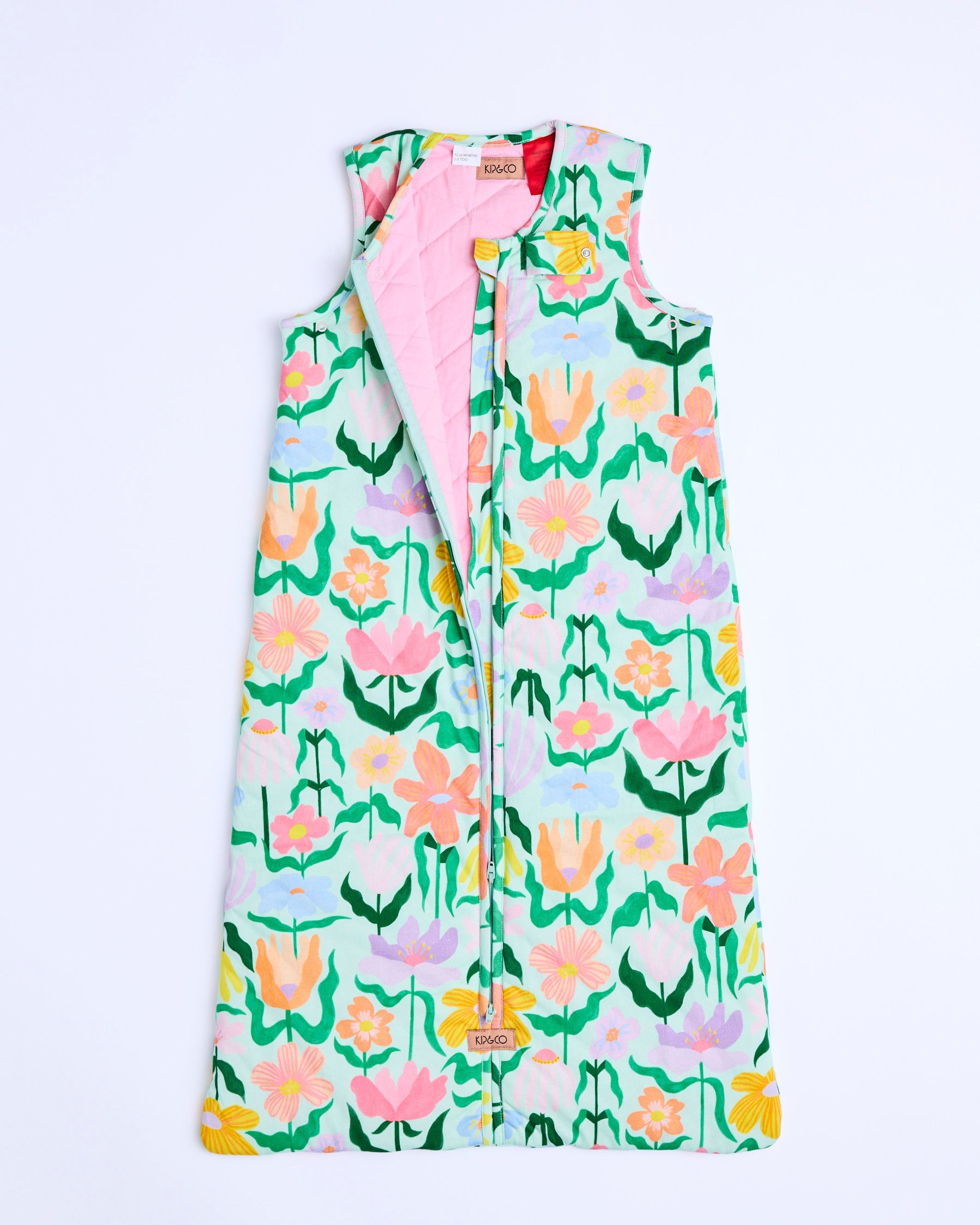 Flat lay of Kip & Co Popping Flowers Green Sleep Bag showing full zipper and floral pattern