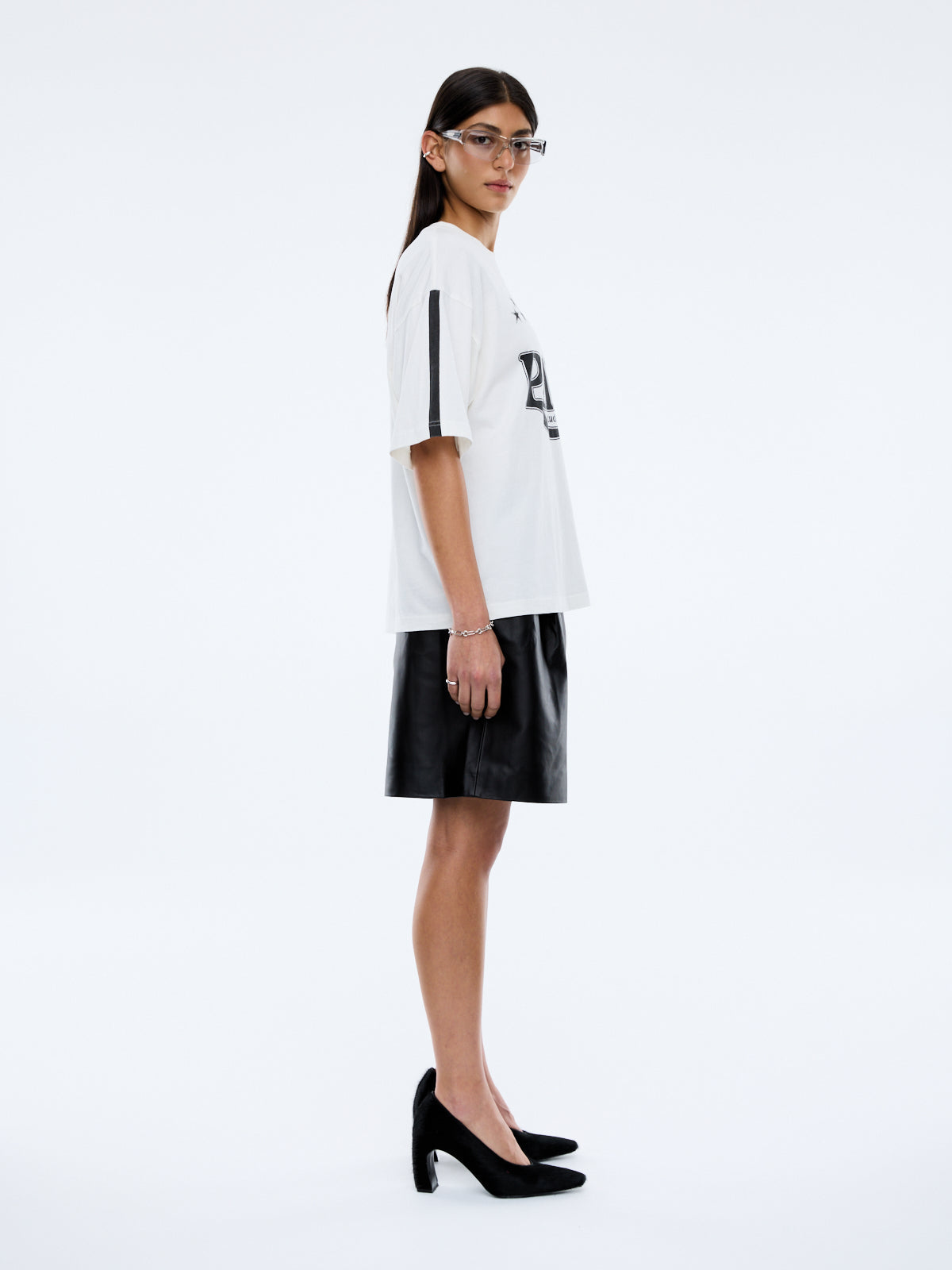 side view of Ena Pelly Racing Pelly Swoop vintage white graphic t-shirt displaying oversized fit and crew neckline