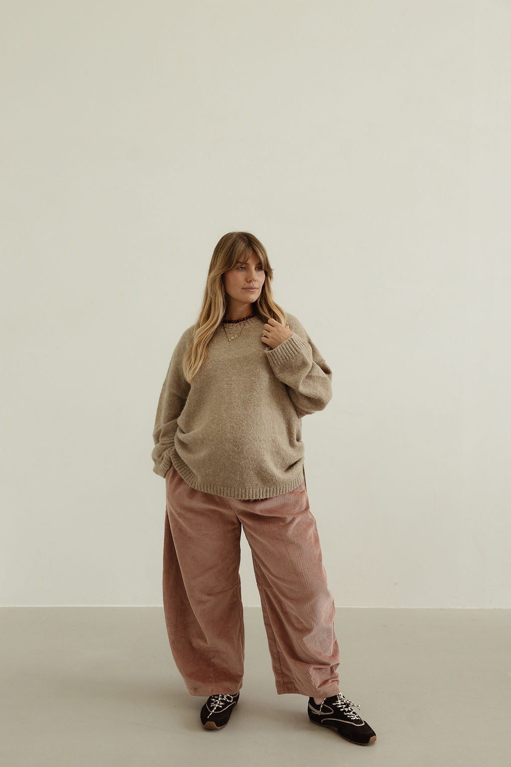 Close-up styling shot of Ren Cord Pant in musk pink showing oversized comfortable fit