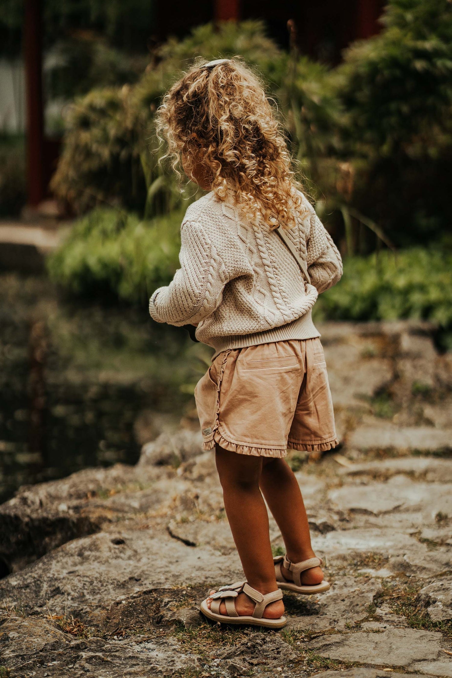 Young girl wearing the Romaine Sweater - Soft Sand | Donsje