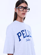 Front view of Sophia Relaxed Tee showing white cotton fabric with blue PELLY Studios graphic print and crew neck