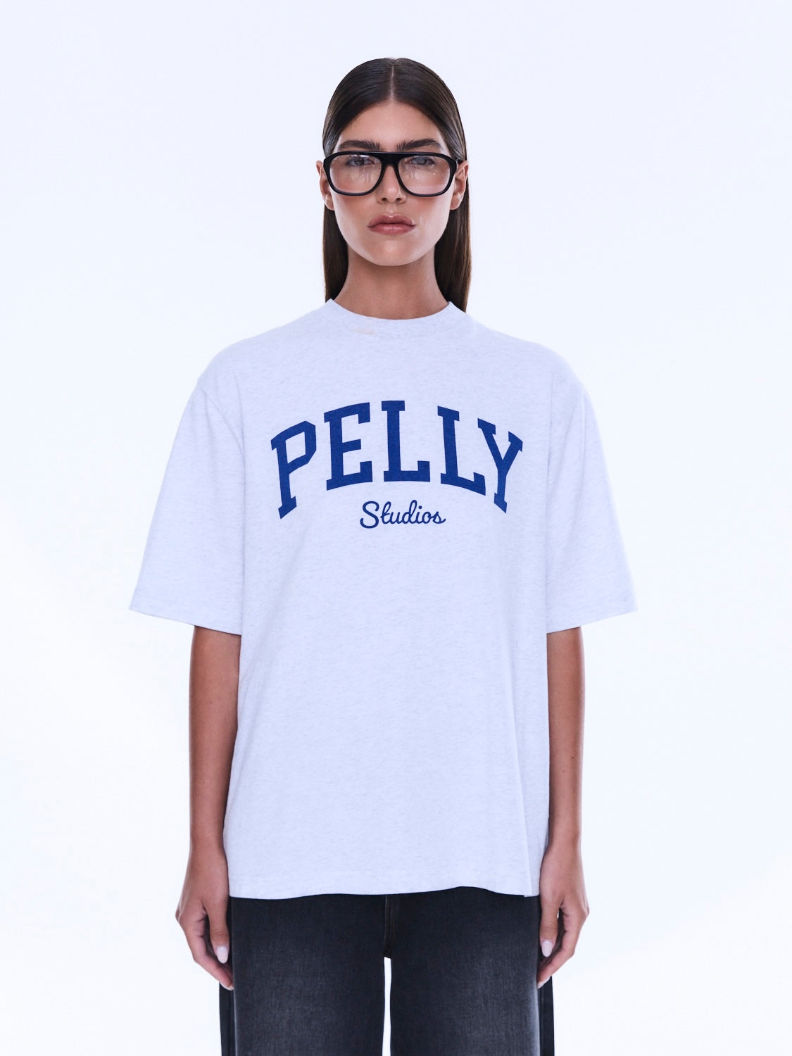 Front detail of Sophia Relaxed Tee featuring blue PELLY Studios collegiate-style lettering on white cotton fabric