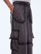 Close up detail of spray effect seams and utility pockets on vintage charcoal cargo pants