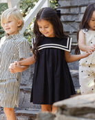 Front view of young girl in the Sailor Dress Black | Rylee + Cru