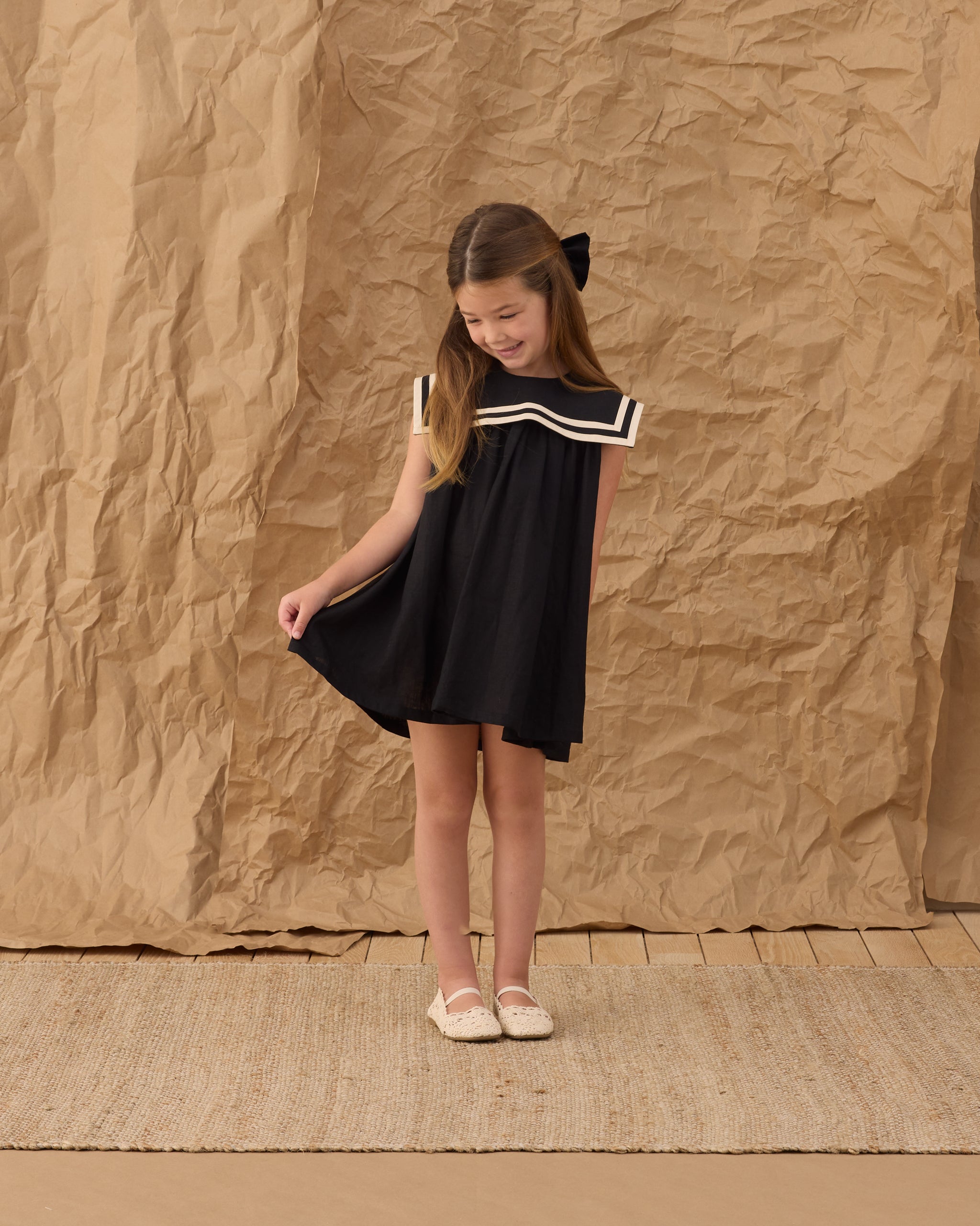 Young girl wearing the Sailor Dress Black | Rylee + Cru