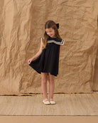 Young girl wearing the Sailor Dress Black | Rylee + Cru