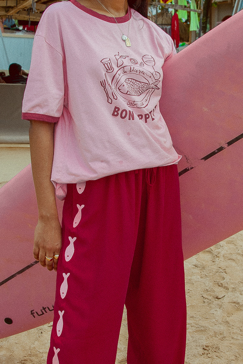 Burgundy and pink womens pants with emroidered fish motif down sides