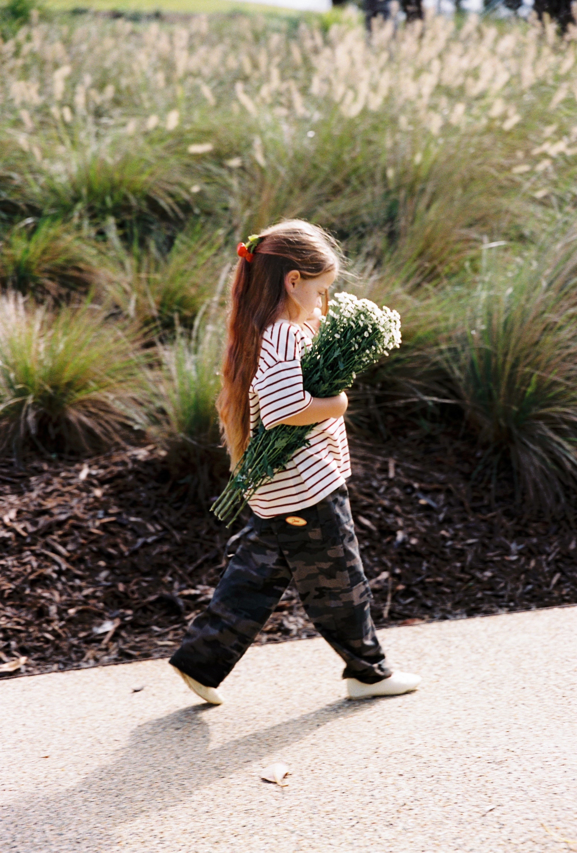 Child walking in camo Scottie Pants showing movement and relaxed fit outdoors