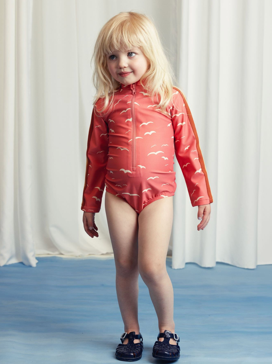 Front view of girl wearing the Seagull Long sleeve Swimsuit - Pink | Mini Rodini