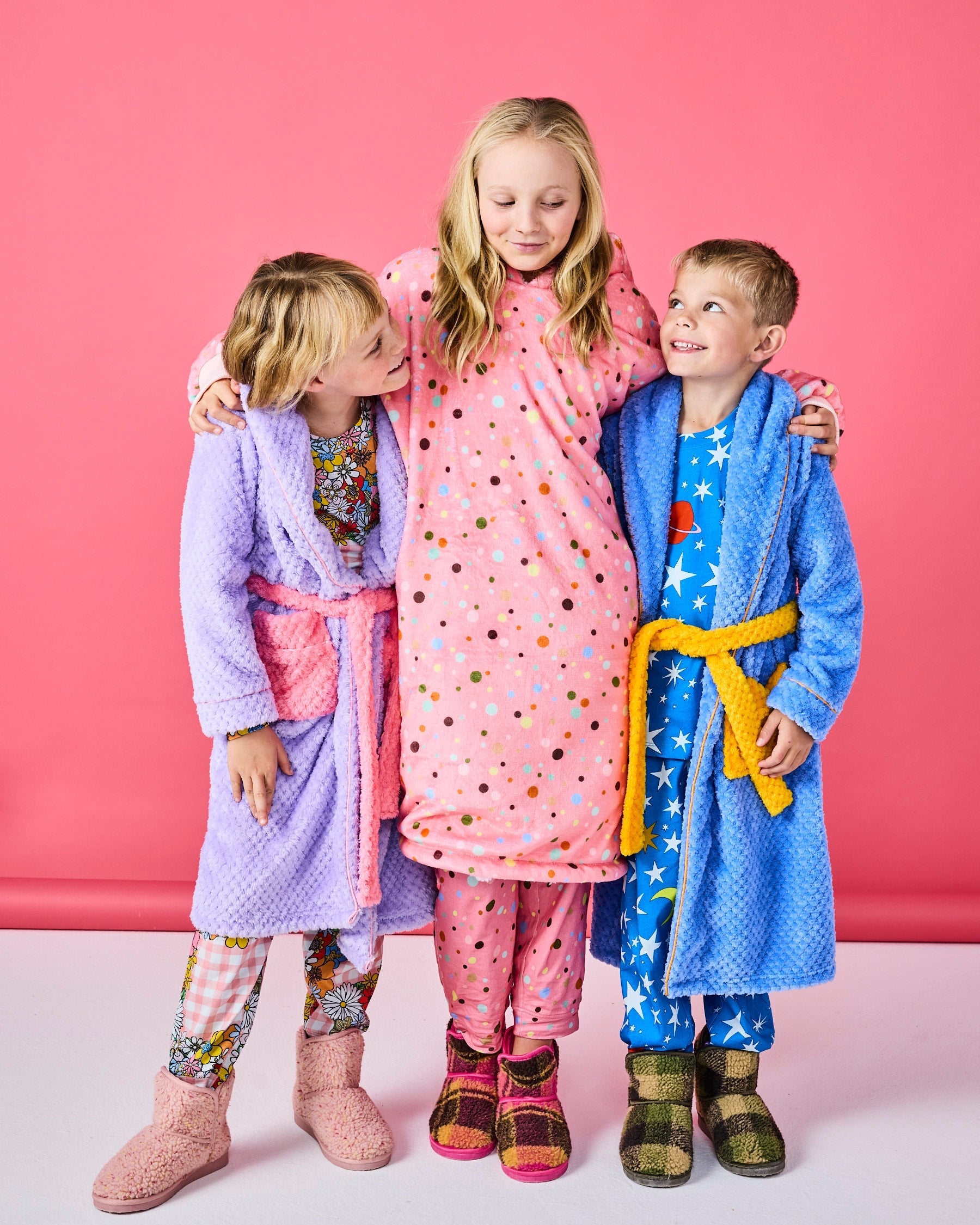 Family wearing matching Kip & Co cosy robes including Seaside Kids robes in blue and purple colors