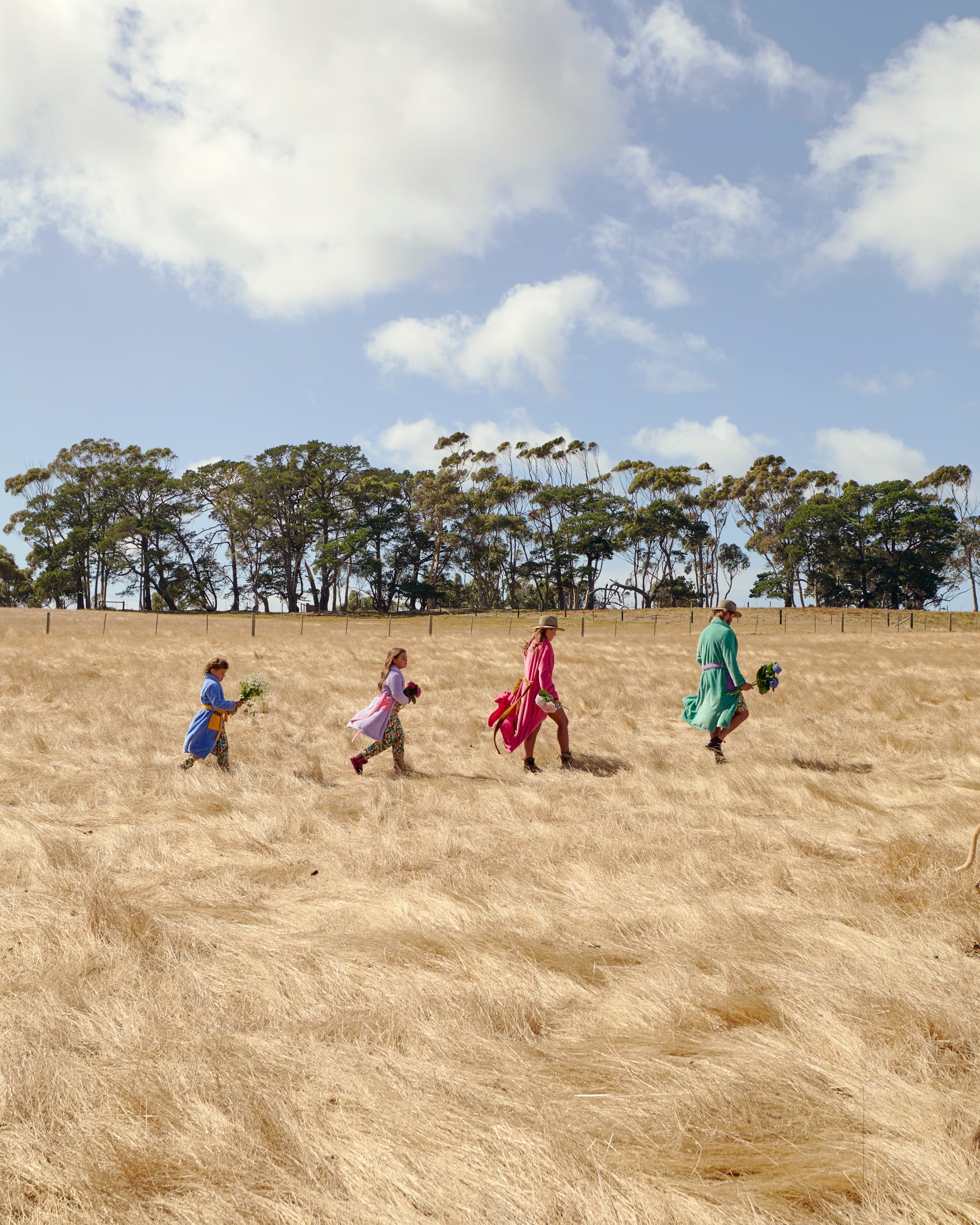 Outdoor lifestyle shot featuring family in Kip & Co Seaside Kids Cosy Robes in countryside setting