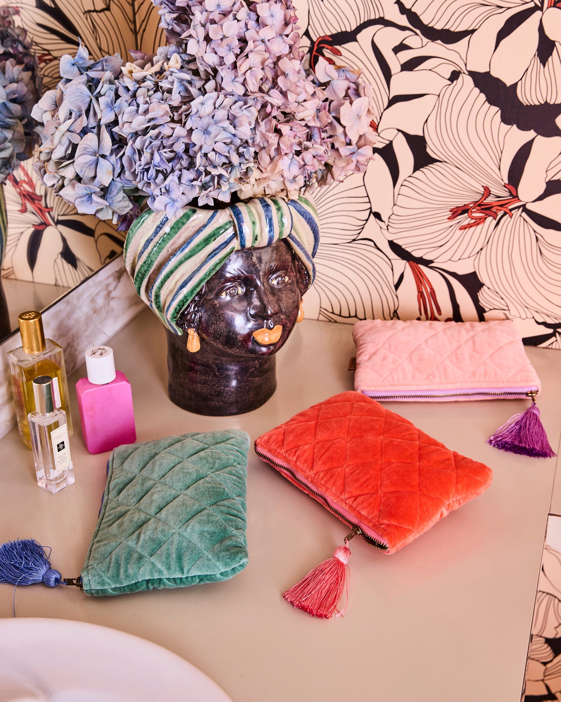 Sherbet Velvet Cosmetics Purse by Kip & Co in coral orange quilted velvet with tassel zipper pull styled with makeup